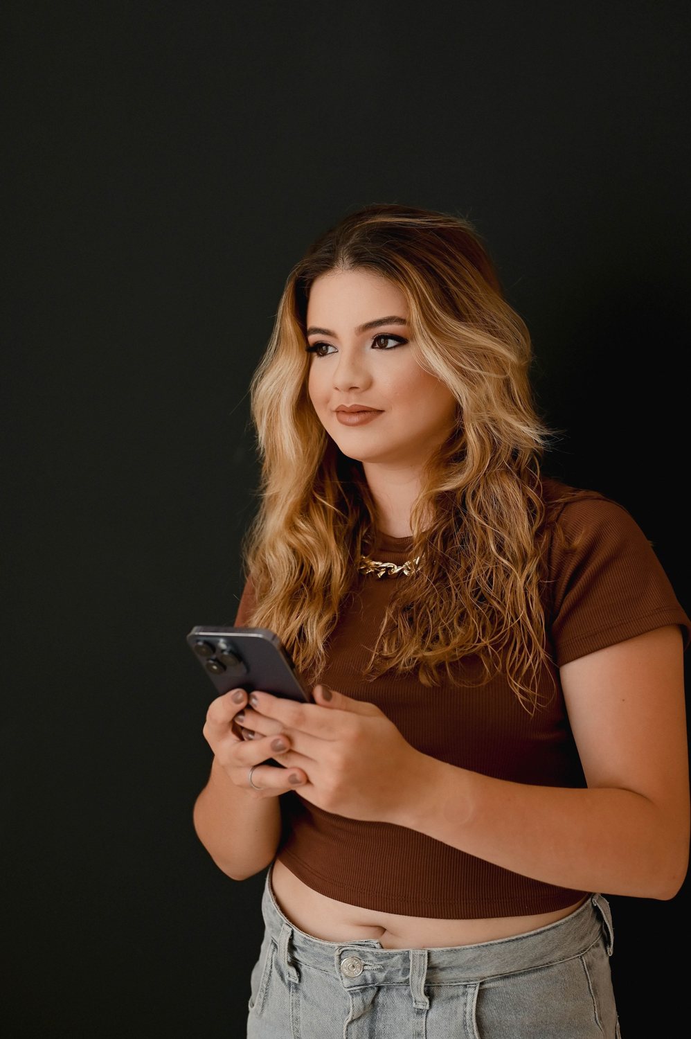 Nicole Louzada segurando o celular
